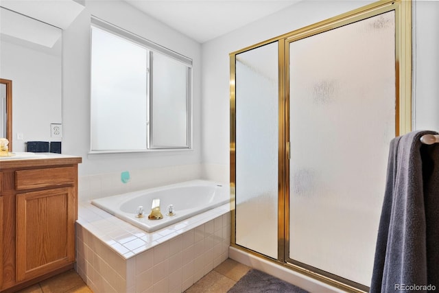 bathroom featuring a stall shower, tile patterned flooring, a garden tub, and vanity