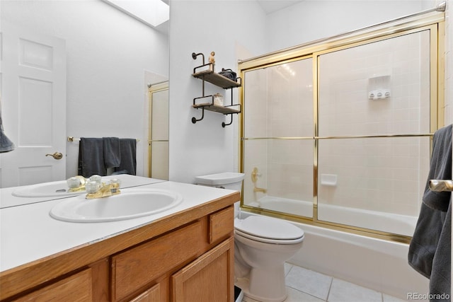 bathroom with toilet, tile patterned flooring, combined bath / shower with glass door, and vanity