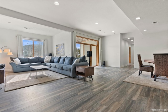 living area featuring visible vents, baseboards, dark wood-type flooring, and recessed lighting