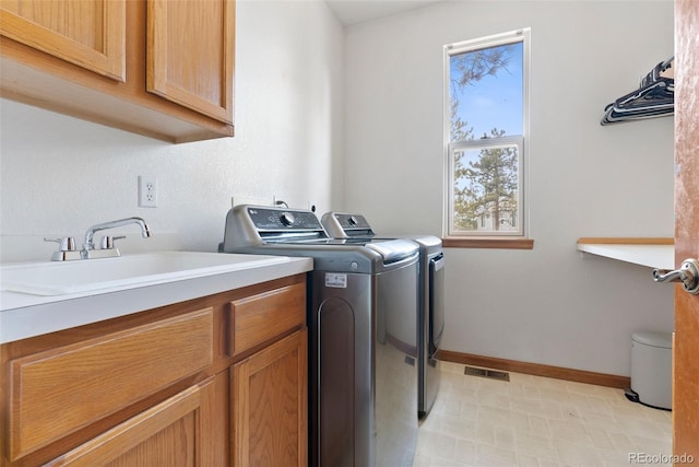 laundry room featuring cabinet space, visible vents, baseboards, independent washer and dryer, and a sink