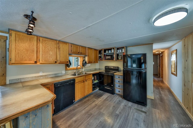 kitchen featuring sink, a textured ceiling, dark hardwood / wood-style flooring, and black appliances