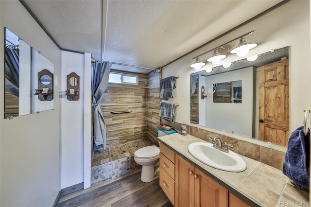 bathroom with walk in shower, toilet, a textured ceiling, vanity, and hardwood / wood-style floors