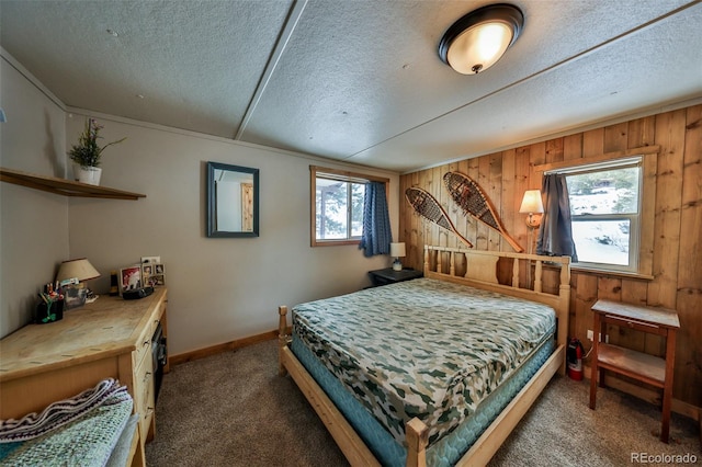 bedroom with dark colored carpet, wooden walls, and a textured ceiling