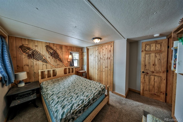 bedroom featuring carpet floors, wooden walls, and a textured ceiling