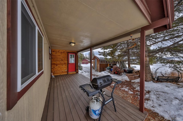 snow covered deck featuring a storage unit