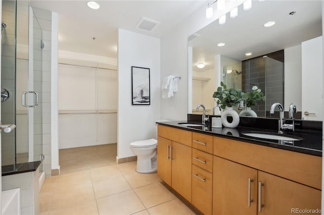 bathroom featuring tile patterned floors, walk in shower, toilet, and vanity