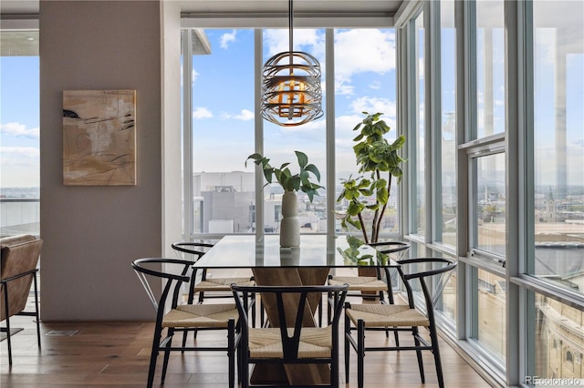 dining area with dark wood-type flooring, an inviting chandelier, and floor to ceiling windows