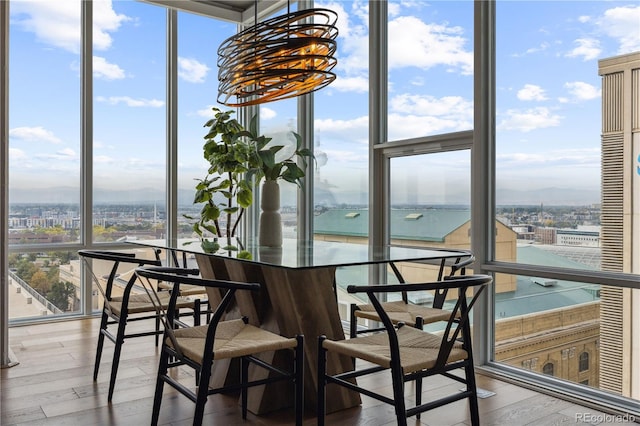 dining space with hardwood / wood-style flooring, expansive windows, a water view, and an inviting chandelier