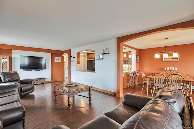 3131 E Alameda Ave Unit 704, Denver, CO 80209 - living room with arched walkways, wood finished floors, a chandelier, and baseboards