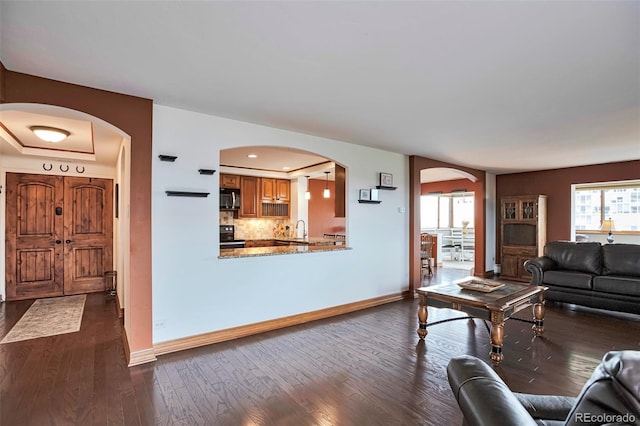 3131 E Alameda Ave Unit 704, Denver, CO 80209 - living area with arched walkways, dark wood-style floors, baseboards, and recessed lighting