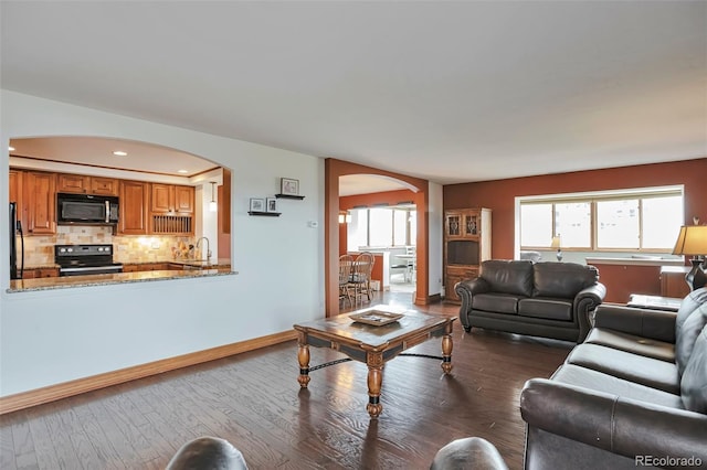 3131 E Alameda Ave Unit 704, Denver, CO 80209 - living area with arched walkways, dark wood-style flooring, baseboards, and recessed lighting
