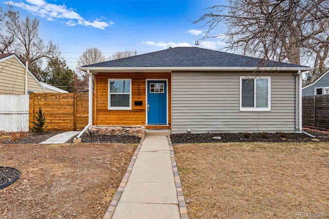 view of front of house featuring a shingled roof and fence