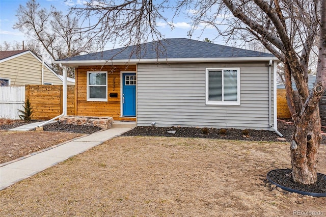 view of front of house featuring fence and roof with shingles