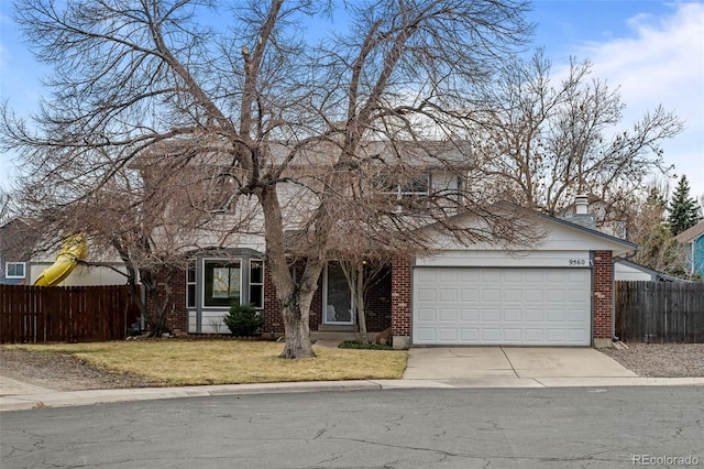 traditional home featuring brick siding, concrete driveway, and fence