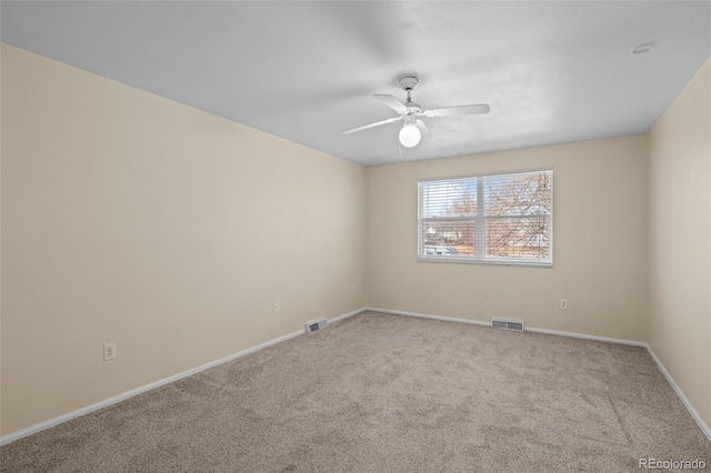 spare room with a ceiling fan, visible vents, carpet floors, and baseboards