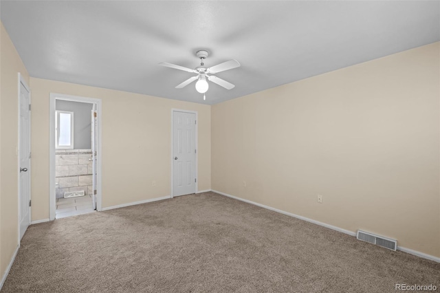 spare room featuring visible vents, carpet flooring, baseboards, and ceiling fan