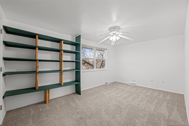 unfurnished bedroom featuring a ceiling fan, carpet flooring, baseboards, and visible vents