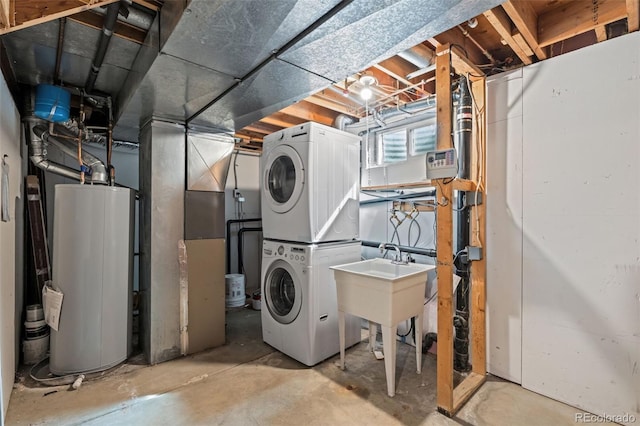 below grade area featuring a sink, stacked washer and clothes dryer, and water heater