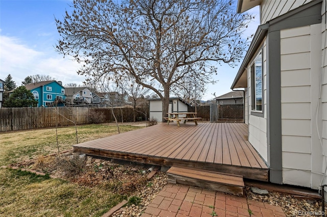 wooden terrace with a yard, a residential view, an outdoor structure, and a fenced backyard