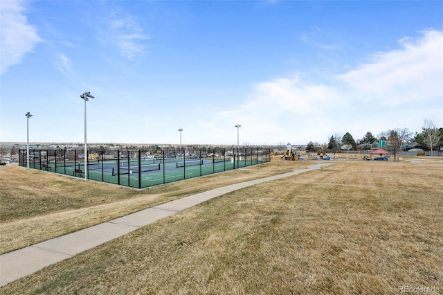 surrounding community featuring a tennis court, a lawn, and fence