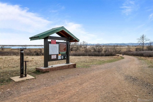 surrounding community featuring a water and mountain view and driveway