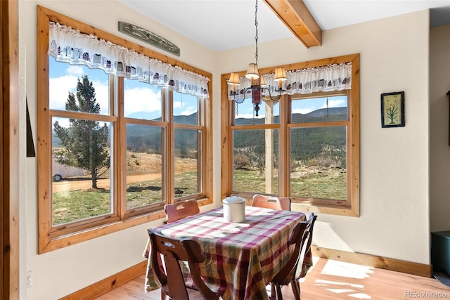 582 Buddy Rd, Bailey, CO 80421 - dining space featuring beam ceiling, wood finished floors, baseboards, a mountain view, and a chandelier