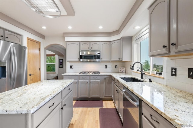 11960 Conestoga Trl, Elbert, CO 80106 - kitchen with a sink, appliances with stainless steel finishes, gray cabinetry, arched walkways, and light wood-type flooring