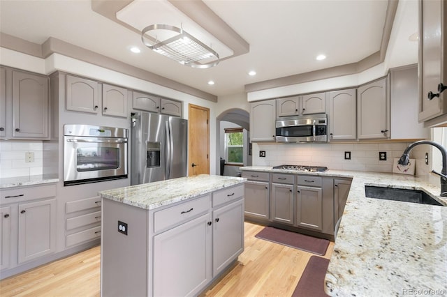 11960 Conestoga Trl, Elbert, CO 80106 - kitchen with appliances with stainless steel finishes, gray cabinets, arched walkways, a sink, and recessed lighting