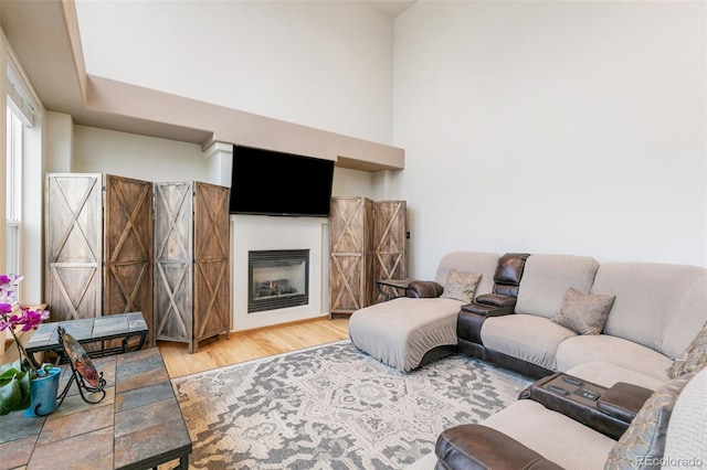 11960 Conestoga Trl, Elbert, CO 80106 - living room featuring wood finished floors, a glass covered fireplace, and a high ceiling