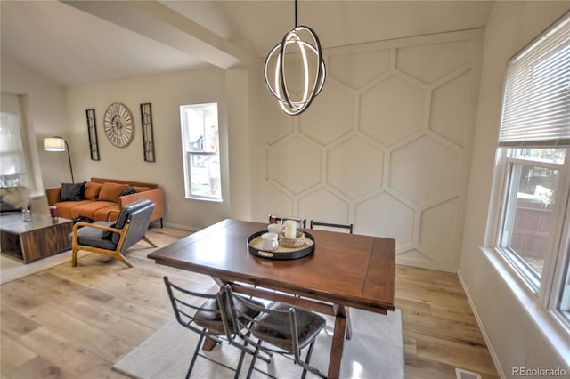 dining room with light hardwood / wood-style flooring and vaulted ceiling