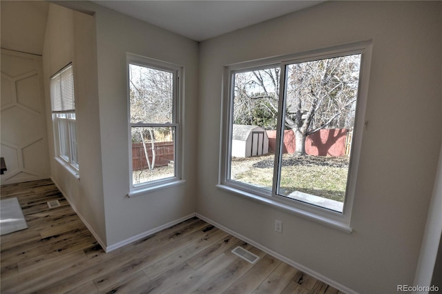 unfurnished dining area featuring hardwood / wood-style floors and a healthy amount of sunlight