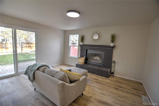 living room with light hardwood / wood-style floors and a fireplace