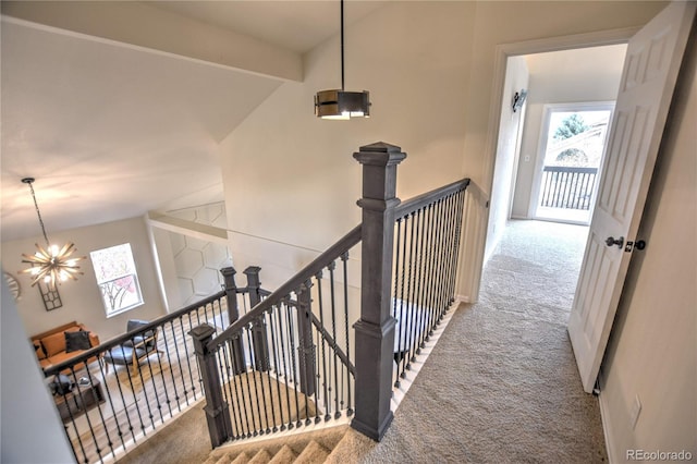 staircase featuring carpet flooring, beam ceiling, and a notable chandelier