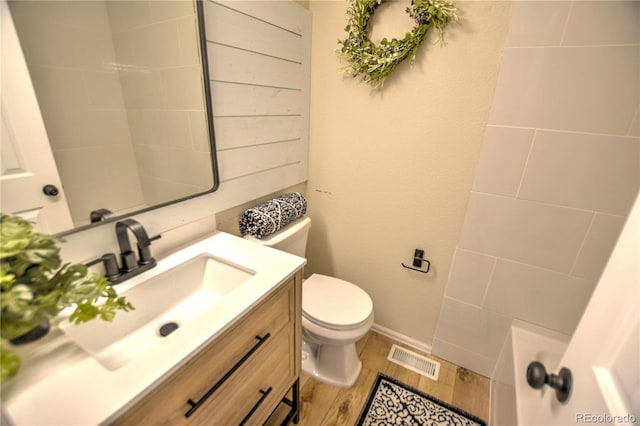 bathroom featuring wood-type flooring, vanity, and toilet