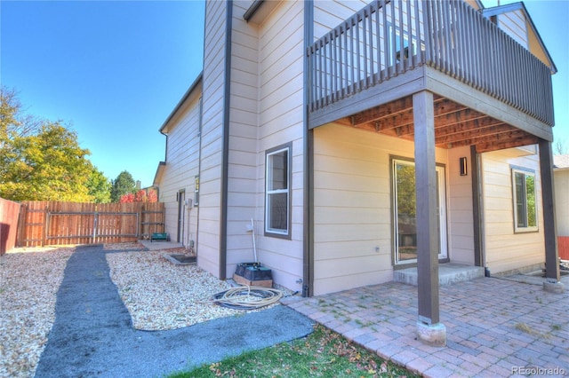 view of home's exterior with a balcony and a patio