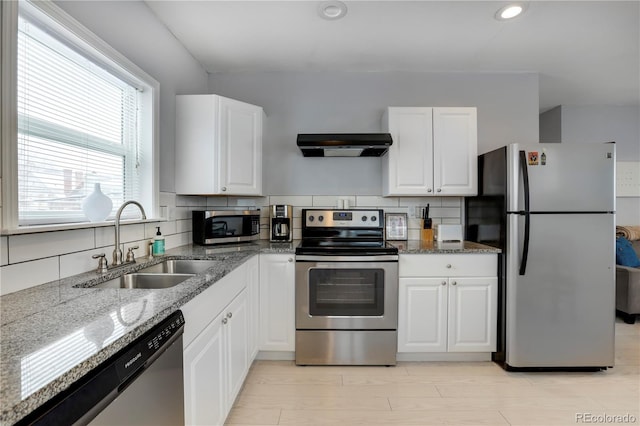 kitchen with sink, ventilation hood, appliances with stainless steel finishes, decorative backsplash, and white cabinets