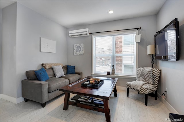 living room with a wall mounted air conditioner and light hardwood / wood-style flooring