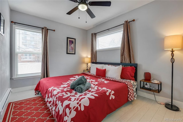 bedroom featuring a baseboard radiator, wood-type flooring, and ceiling fan