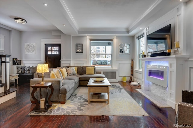 living room with crown molding, plenty of natural light, and dark hardwood / wood-style floors