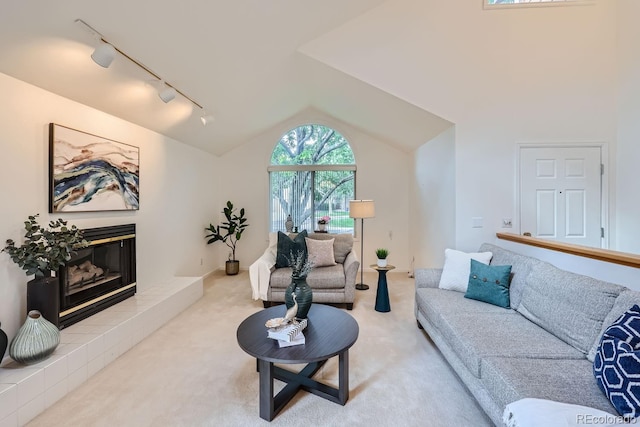 carpeted living room with lofted ceiling and track lighting