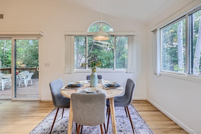 dining space featuring light hardwood / wood-style flooring and vaulted ceiling