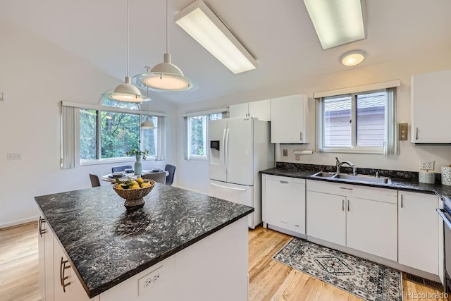 kitchen featuring light hardwood / wood-style floors, white cabinets, white appliances, a center island, and decorative light fixtures