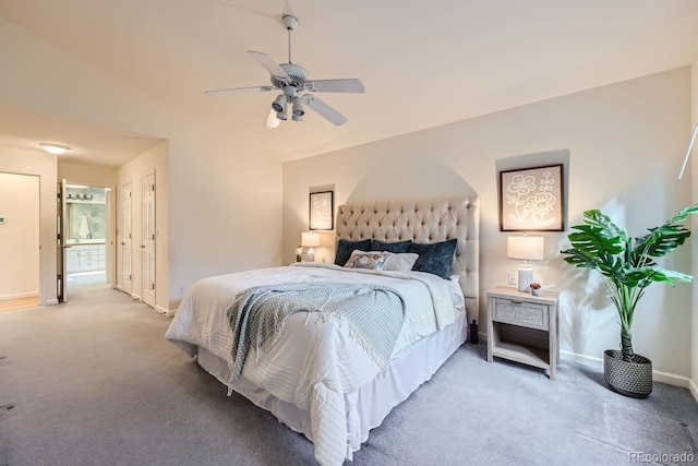 carpeted bedroom with connected bathroom, vaulted ceiling, and ceiling fan