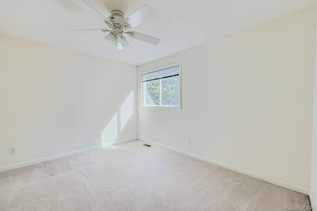 empty room with ceiling fan and light carpet