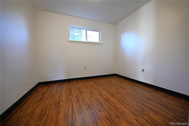 empty room with dark hardwood / wood-style flooring