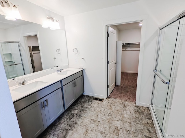 bathroom with a shower with door and vanity