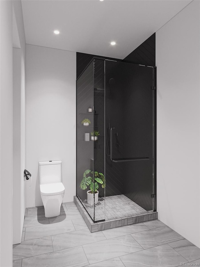 bathroom featuring a shower with door and toilet