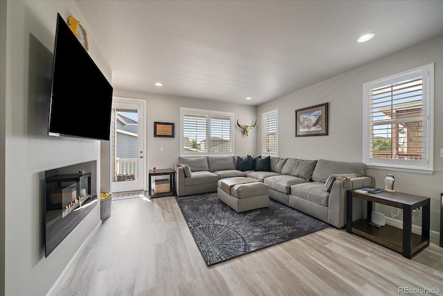 8908 Birch Run Ln, Parker, CO 80134 - living room with light wood-style floors, a glass covered fireplace, and recessed lighting