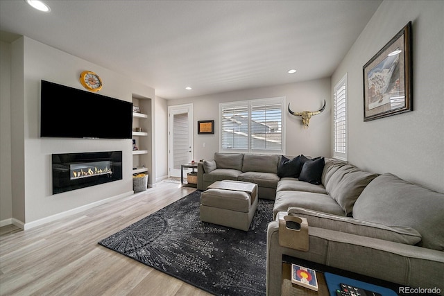 8908 Birch Run Ln, Parker, CO 80134 - living area with wood finished floors, built in features, a glass covered fireplace, and recessed lighting
