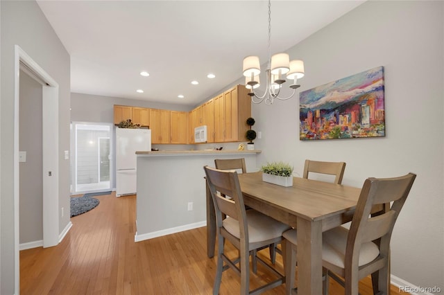 dining area with light wood-style flooring, baseboards, a notable chandelier, and recessed lighting